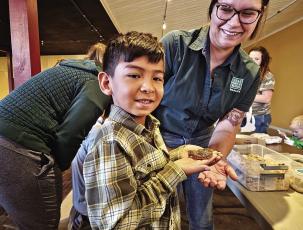 Eli Villanueva holds a juvenile bullsnake with the help of Presidio County biologist Rachael Connally. Connally and her colleagues with Texas Parks and Wildlife were on hand at Alpine’s Earth Day celebration held at Kishmish Plaza displaying mammal pelts, antlers, and live, non-venomous snake species found in the Trans-Pecos. Photo by Kara Gerbert