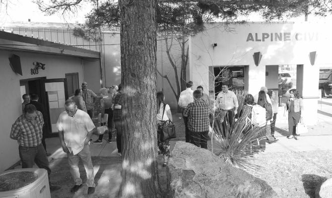 Elected officials and members of the community congregate outside the city council chambers after the joint workshop of Brewster County and the City of Alpine with the Texas Department of Transportation.