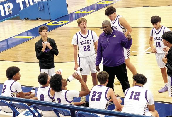 Coach Aaron Hardwick gives his varsity squad some pointers as they prepare to get back onto the hardwood. Courtesy photo