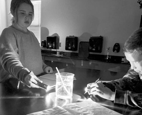 Fifth graders Rynn Matthews and Cutter Baeza investigate the properties of light reflection and refraction during science class. Courtesy photo