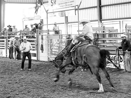 A bronc rider grips the halter rope with his hand and the horse with his legs during the opening bronc riding event at this year’s Big Bend Ranch Rodeo. Bronc riders in this event use an everyday, working western saddle just as they would when breaking a horse on the ranch. Photo by Kara Gerbert