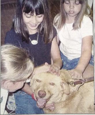 April 17, 2003 – Amanda Locke, Brittany Polanco, and Jessica Heinatz play with drug dog Mattie, a Labrador mix from the Hill Country Dog Center. These girls from Girl Scout Troop 472 participated in a law enforcement demonstration as part of a merit badge project.