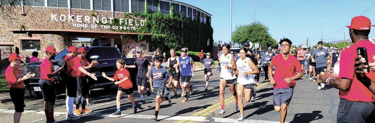 Runners take off at the sixth annual Alpine o6 Cowboys Home Run 5K in front of historic Kokernot Field in Alpine on May 29, while Cowboy team members cheer them on. All finishers received a handcrafted ceramic medal by local artist Pauline Hernandez. After the race, the Cowboys hosted a meet and greet with the players, followed by an intersquad game, with hotdogs, chips and drinks provided for fans. Avalanche photo by Roxanne Hill