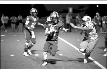 Logan Smith carries the ball with teammate Devon Rojo behind him in the game against Wink on Friday. Photo by Noe Lujan
