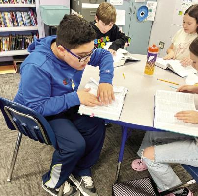 Students at Alpine Middle School engage in dictionary wars by looking up words and defining them for team points. Courtesy photo