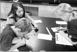 Alpine Middle School science students investigate properties of matter in a recent science class, including magnetism, states of matter, relative density, and solubility. Courtesy photo