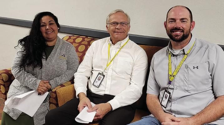 Principals Judith Pardo-Alferez, Curtis Wubbena, and Jarrett Vickers pause for a photo outside the Alpine ISD Administration Building Board Room.