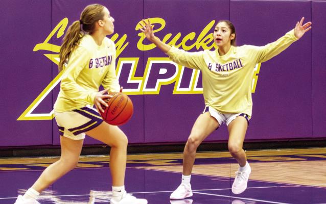 Evelyn Smith pushes toward the hoop as team member Andynne Ramirez attempts to block her potential shot during a pre-game warm-up. Photo by Kara Gerbert