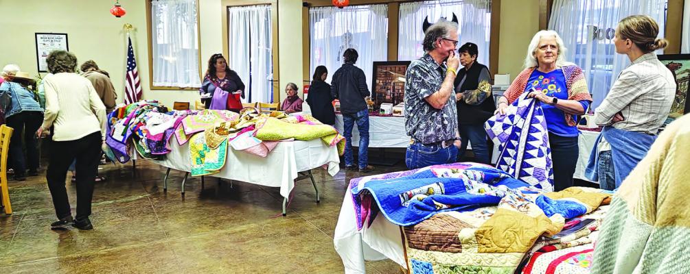 Above: Supporters of the Sunshine House peruse quilts and other raffle items on hand during Wild West Night on Saturday. Right: Andy Ramos and Ward 4 Councilman Martin Sandate visit with friends during the Sunshine House’s Wild West Night on Saturday. Photos by Kara Gerbert