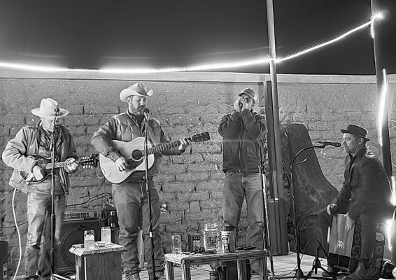 The Late Comers performed Sunday night at the Hotel Ritchey and ushered in the new year as the closing act. From left, Ross Fleming on mandolin, Neil Trammell on guitar and vocals, Todd Elrod on harmonica, and Tony Curry on cajón. Photo by Kara Gerbert