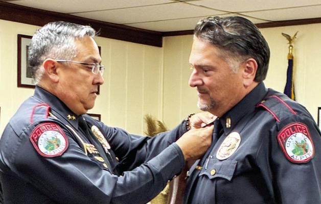 Alpine Police Chief Darrell Losoya proudly pins the collars of the newly sworn-in Chief of Police Kirk Caughman during Tuesday night’s city council meeting. Photo by Felipe Fierro