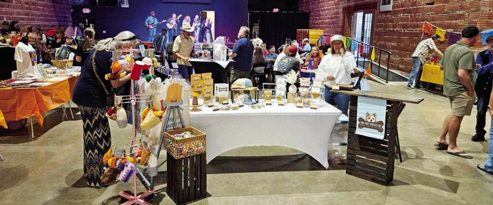 The Doodlin Hogwallops perform in the background at last year’s Dia de los Quesos, the annual fundraiser put on by the Alpine Humane Society, as attendees look over the many items on display at the silent auction. Courtesy photo