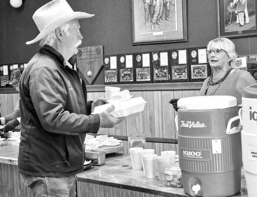 Tommy Mangrem chats with Kay Tscheyka as he picks up his catfish dinner and drink last Friday at the Alpine Public Library’s Fish Fry fundraiser. The fundraiser had a large turnout with music by the Swifts and A Few Too Many. Photo by Kara Gerbert