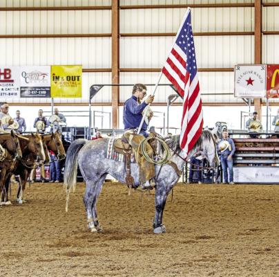 Before every rodeo, including the Big Bend Ranch Rodeo, held in Alpine this past weekend, cowboys, cowgirls, and spectators alike remove covers and place their hands over their hearts to pay tribute to the flag and America with the national anthem. Photo by Kara Gerbert