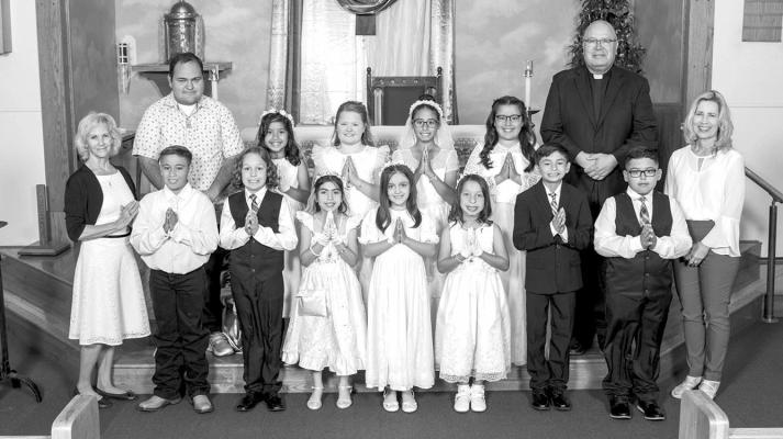 The First Communion celebration and Mass was held at Our Lady of Peace Catholic Church on Saturday, April 15. From left, bottom row: Catechist-Cynthia Wood, Aiden Gonzalez, Troy Vidal, Dazia Villareal, Willow Velasco, Melinda Rodriguez, Mason Losoya, Lucas Valenzuela, and Catechist-Barbara Tucker. In back, from left: Catechist-Manuel Martinez, Emma Sanchez, Zoe Wood, Nathalia Rosas, Camila Loya, and Fr. Pablo Matta. Courtesy photo