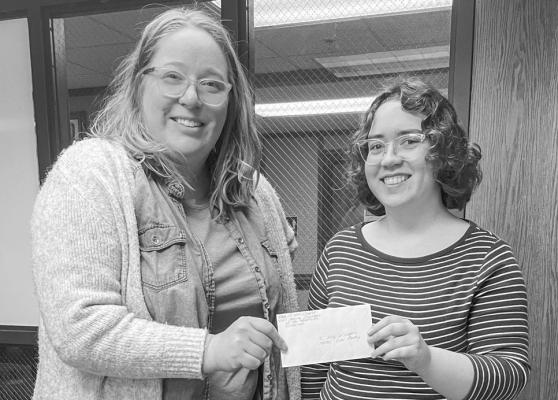 Katy Williams accepts a check from Muriel Cotman as part of a donation to the Sul Ross Lobo Pantry from the Daughters of the American Revolution, Paisano Chapter.