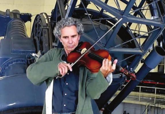 Research Engineer John Kuehne plays a sea shanty on viola on the deck of one of McDonald Observatory’s telescopes. Courtesy photo