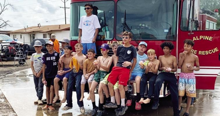 Thanks to a bit of help from the Alpine Fire Department, these young Little League all-stars took some time to cool off on Saturday during their fundraiser bake sale. Photo by Hazel Mercado
