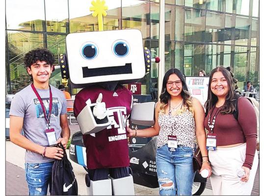 Marfa High School students Juan Avila, Alexis Gonzales, and Aubrie Aguilar engage with an engineering robot at Texas A&amp;M University in College Station.