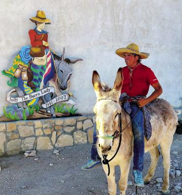 George Delgado sits atop his trusty burro “Rojo” in front of a memorial to Judy Magers aka “The Burro Lady”. Courtesy photo