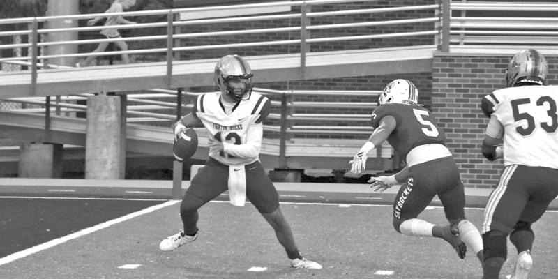 Fightin’ Buck quarterback Devon Rojo searches for an open receiver last Friday night in Abilene against a tough Wellington defense. Photo by Noe Lujan
