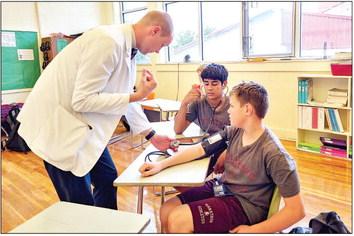 Fourth year medical student Kyle McDaniel from Texas Tech University Health Science Center-Permian Basin teaches Joe David Gonzales and Keller Barlow how to manually take blood pressure during one of three presentations he gave to students at the Marathon High School. Photo by Kara Gerbert