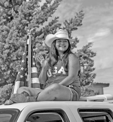 Haley Muniz waves to the crowd atop the Cowboy Cleaners truck in this year’s July 4 parade. Photo by Kara Gerbert