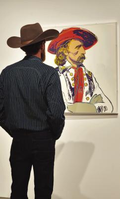 An art enthusiast ponders Andy Warhol’s rendition of General Custer that is part of the Cowboys and Indians display at the Museum of the Big Bend. Photo by Kara Gerbert