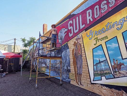Artist Stylle Read took advantage of the shade in 2025 as he performed maintenance on the large mural that graces the wall of Vise Coffee on the corner of 5th Street and Holland Avenue. Photo by Kara Gerbert