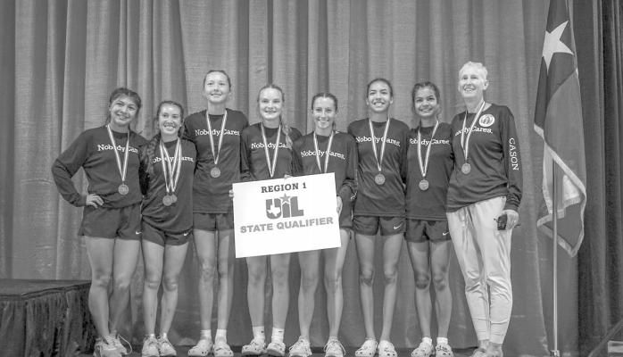 The Alpine Lady Bucks cross-country team poses with their state qualifying signs after their thirdplace team win in Lubbock this past Saturday. Courtesy photo
