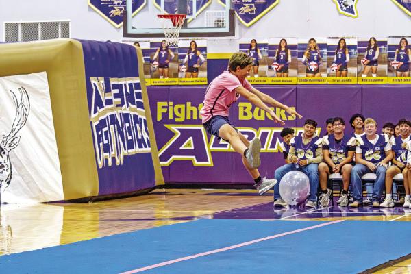 Alpine’s freshman cross-country runner Barry Young tries his hand at cheerleading during last week’s pep rally at the AHS gym, as the varsity football team looks on. Photo by Kara Gerbert