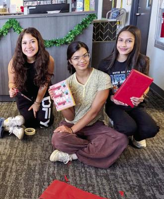 The AHS Student Council hosted a book swap last week in honor of Read Across America Day. Students could trade pre-read books for a fresh read before they headed into spring break. Pictured are Vianney Santos, Megan Struthers, and Leah Struthers. Courtesy photo