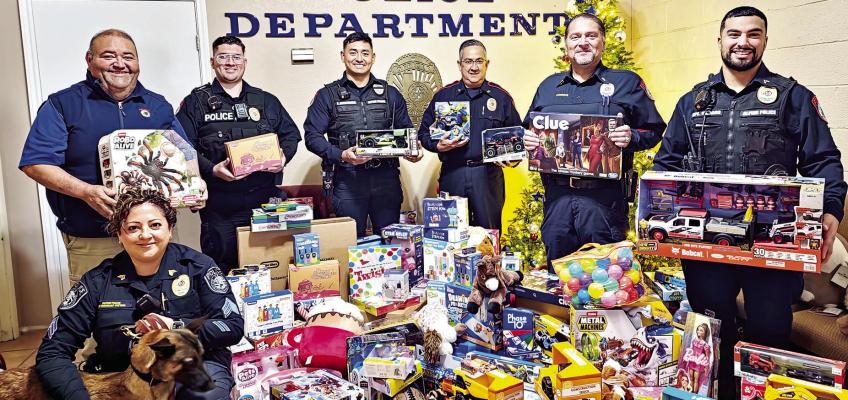 Alpine Police Department’s Blue Santa program is collecting gifts for underprivileged children again. Those wishing to donate may drop the gifts off in the lobby. Pictured are APD officers Prada with her handler Valerie Kettani, Felipe Fierro, Victor Santana, Alexis Armendariz, Chief Darrell Losoya, Kurt Caughman, and Anthony Vargas. Photo by Kara Gerbert
