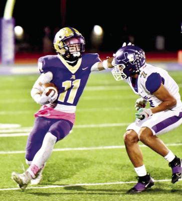 Logan Smith carries the ball, rushing around a Crane player during last week’s game. Photo by Noe Lujan