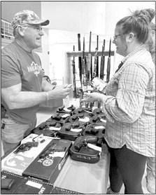 Dodson Guns owner Ronny Dodson discusses pistols with a patron at the annual Lions Club Gun and Knife Show held Sept. 3-4 at the Gallego Center in Alpine. Avalanche photo by Gail Diane Yovanovich