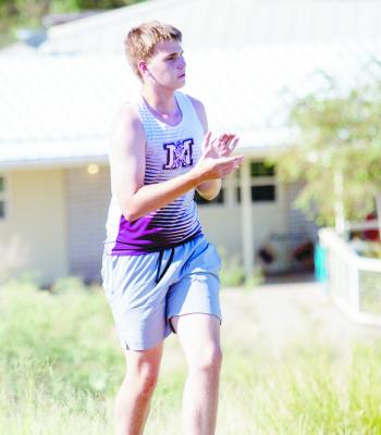 Marathon’s Ethan Fogle cheers on a fellow teammate (not shown) as they tackle the hill on Alpine’s Loop Road during this past Saturday’s cross-country race. Photo by Kara Gerbert