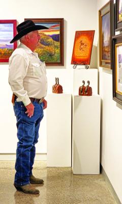 Sam Dove, a local working cowboy, admires some of the outstanding Western artwork on display at the Museum of the Big Bend during this past weekend’s Trappings of Texas exhibit. Photo by Kara Gerbert