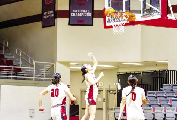 Ariana Escalante and Leslie Mojica watch as Senior Victoria Aguayo hits a layup. Photo by Kara Gerbert