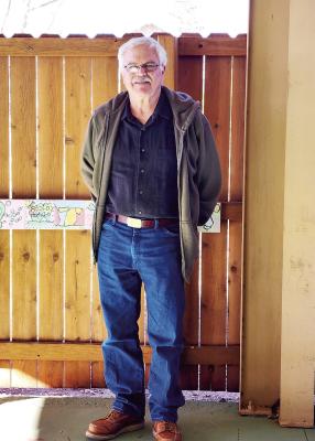 Alpine Public Library’s Director, Don Wetterauer, stands on the west side porch the library plans to expand.