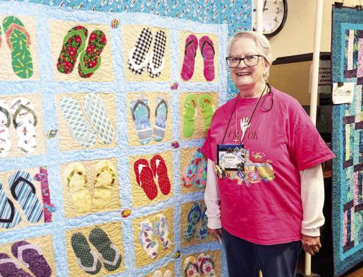 Robbie Burns stands beside one of several quilts she had on display this past Saturday at the Desert Sky Quilt Show held at the Sunshine House. Photo by Kara Gerbert