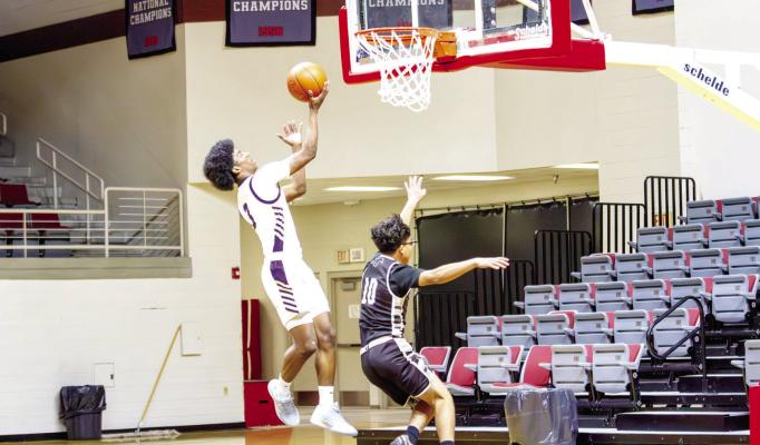 Alpine Buck senior Dae Hardwick leaps above a Fort Hancock defender during last Friday morning’s first game in the Wilson- Stice Invitational. The Bucks toppled the Mustangs 79-29 at the Pete P. Gallego Center. Photo by Kara Gerbert