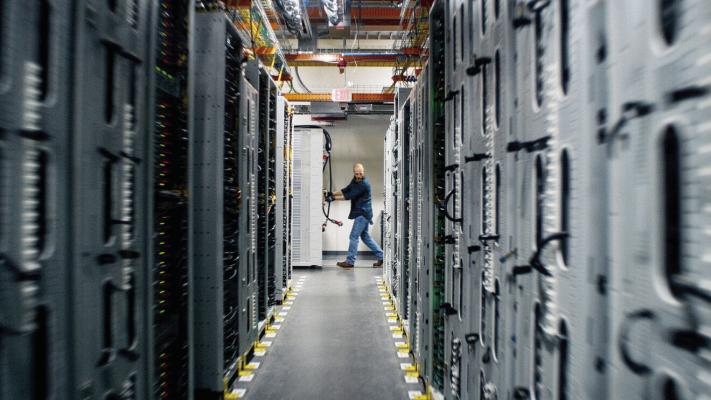Dallin Puzey, a manager for an AWS infrastructure delivery team, rolls in a new rack with network devices to be installed in eastern Oregon. Courtesy photo