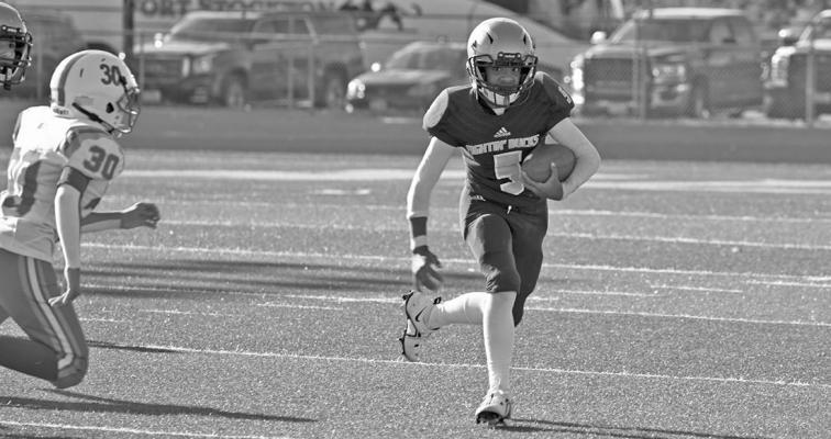 Eighth- grade quarterback Luis Lujan scrambles away from Van Horn defensemen last Thursday in the Bucks’ defeat over the Eagles. Photo by Felipe Fierro