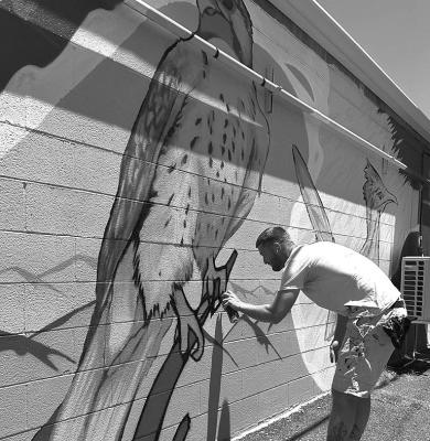 Monty Welt creates another mural to enhance downtown Alpine. This mural is located on the back of City Drug. Photo by J.T. Maroney
