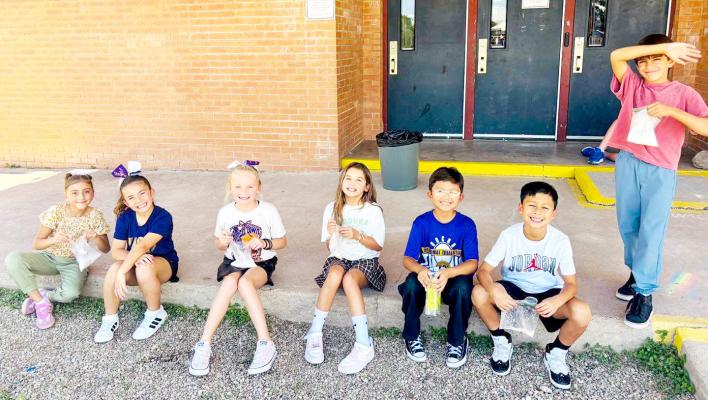 These Alpine Elementary third graders sat down outside last week to enjoy the instant ice cream they learned to make in science class. Courtesy photo