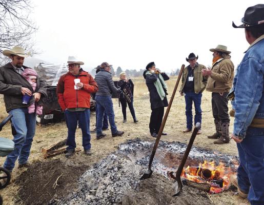 Cowboy poets and future wordsmiths alike try to stay warm by congregating around the fire during Saturday morning’s chuckwagon breakfast at the Lonestar Cowboy Poetry Gathering. Photo by Kara Gerbert