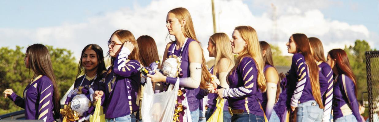 The Lady Buck volleyball team holds sacks of candy that they throw to the crowd during this year’s Homecoming parade.