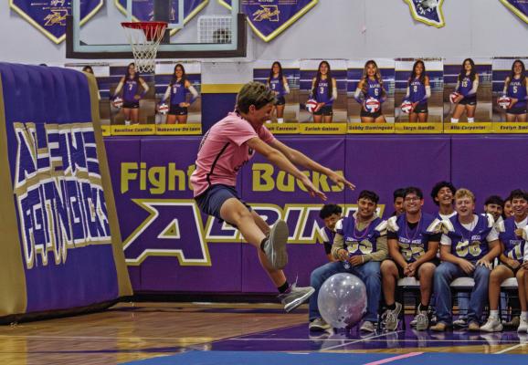 Alpine’s freshman cross-country runner Barry Young tries his hand at cheerleading during a 2025 pep rally at the AHS gym, as the varsity football team looks on. Photo by Kara Gerbert