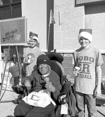 Tripp and Brody Warren along with Eddie Leyva of Alpine ring the bells for the Salvation Army donation pot located in front of Porter’s Thriftway recently. Courtesy photo by Shelley Shackelford