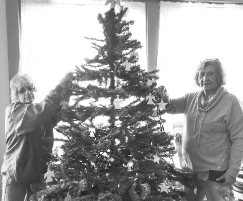 Noreen Geehan and Petra Tucker place memory ornaments on the Angel Tree, set up in the dining room of the Sunshine House. Avalanche photo by Kara Gerbert